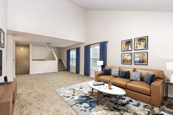 A living room with a brown couch and a coffee table.